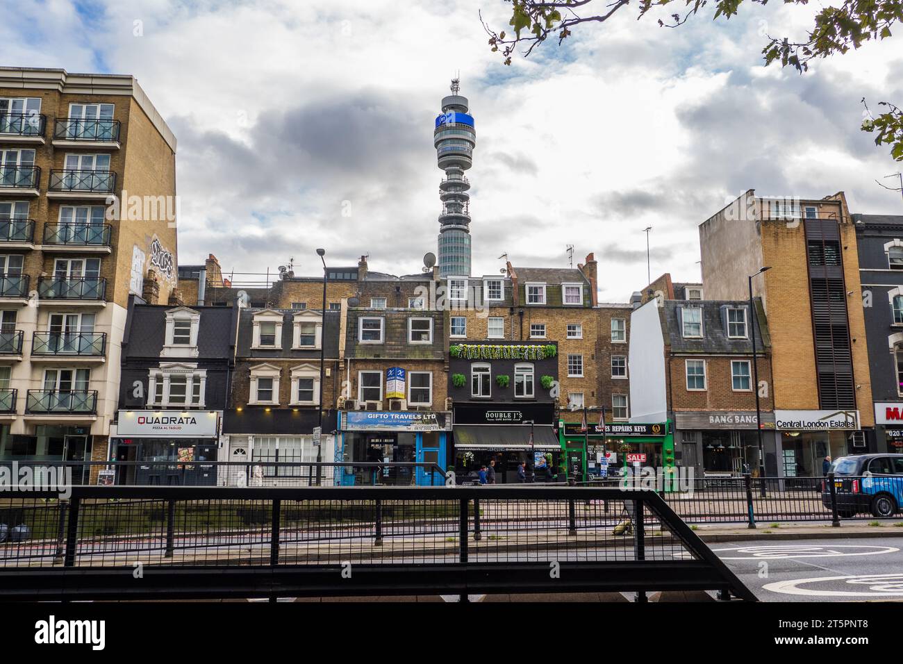 Die Gegenüberstellung der Einkaufsstraße Old Euston Road, die im November 2023 mit dem BT Tower in London umrahmt wurde Stockfoto