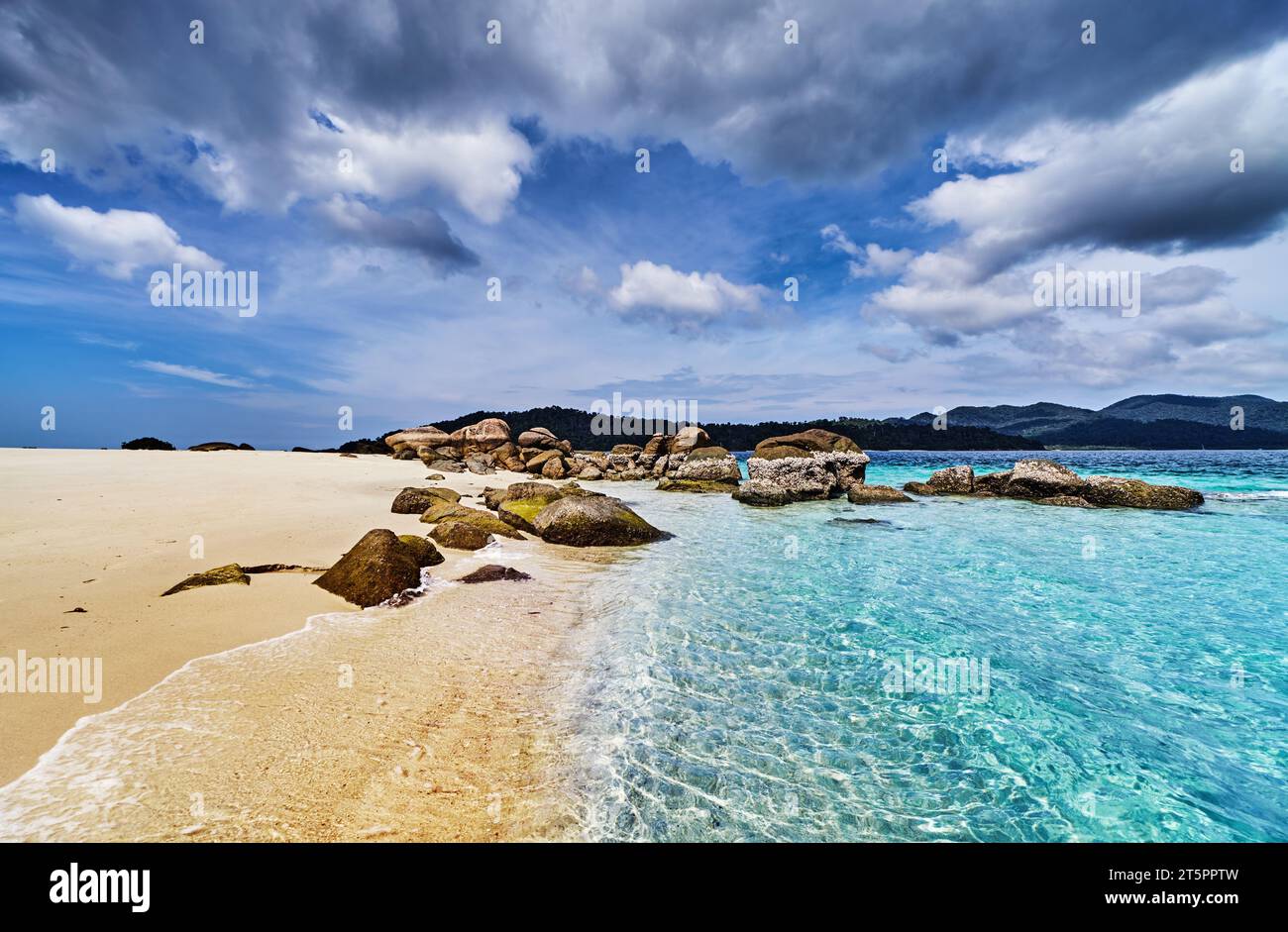 Wunderschöner tropischer Strand mit klarem türkisfarbenem Wasser und blauem Himmel mit Wolken in Thailand Stockfoto