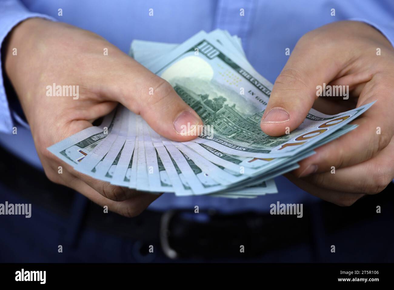 US-Dollar in männlicher Hand, Mann in Geschäftskleidung zählt das Geld. Konzept der Bestechung, des Gehalts, der finanziellen Unterstützung oder des Darlehens Stockfoto