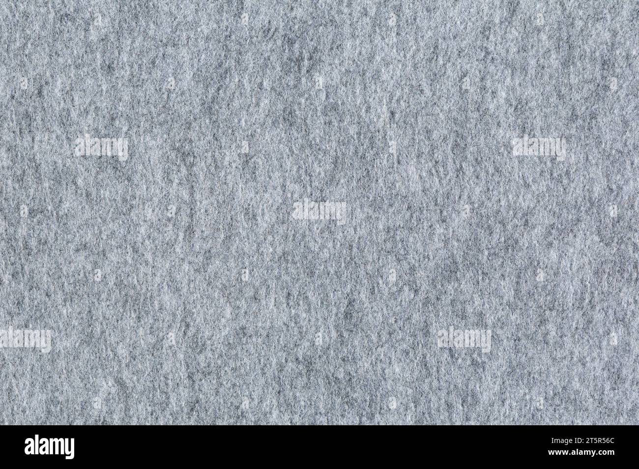 Filzstruktur, Nahaufnahme. Weiches graues Filzmaterial. Oberfläche des gefilzten Gewebes. Abstrakter Hintergrund in grauer Farbe. Stockfoto
