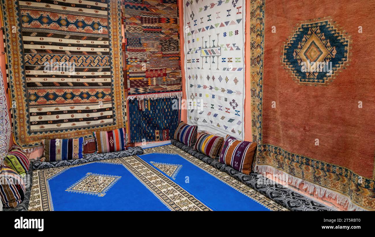Zimmer voller marokkanischer Teppiche. Ein marokkanischer Teppich ist ein handgewebtes Meisterwerk, das von erfahrenen Handwerkern gefertigt wurde. Diese Teppiche verfügen über geometrische Muster und VI Stockfoto