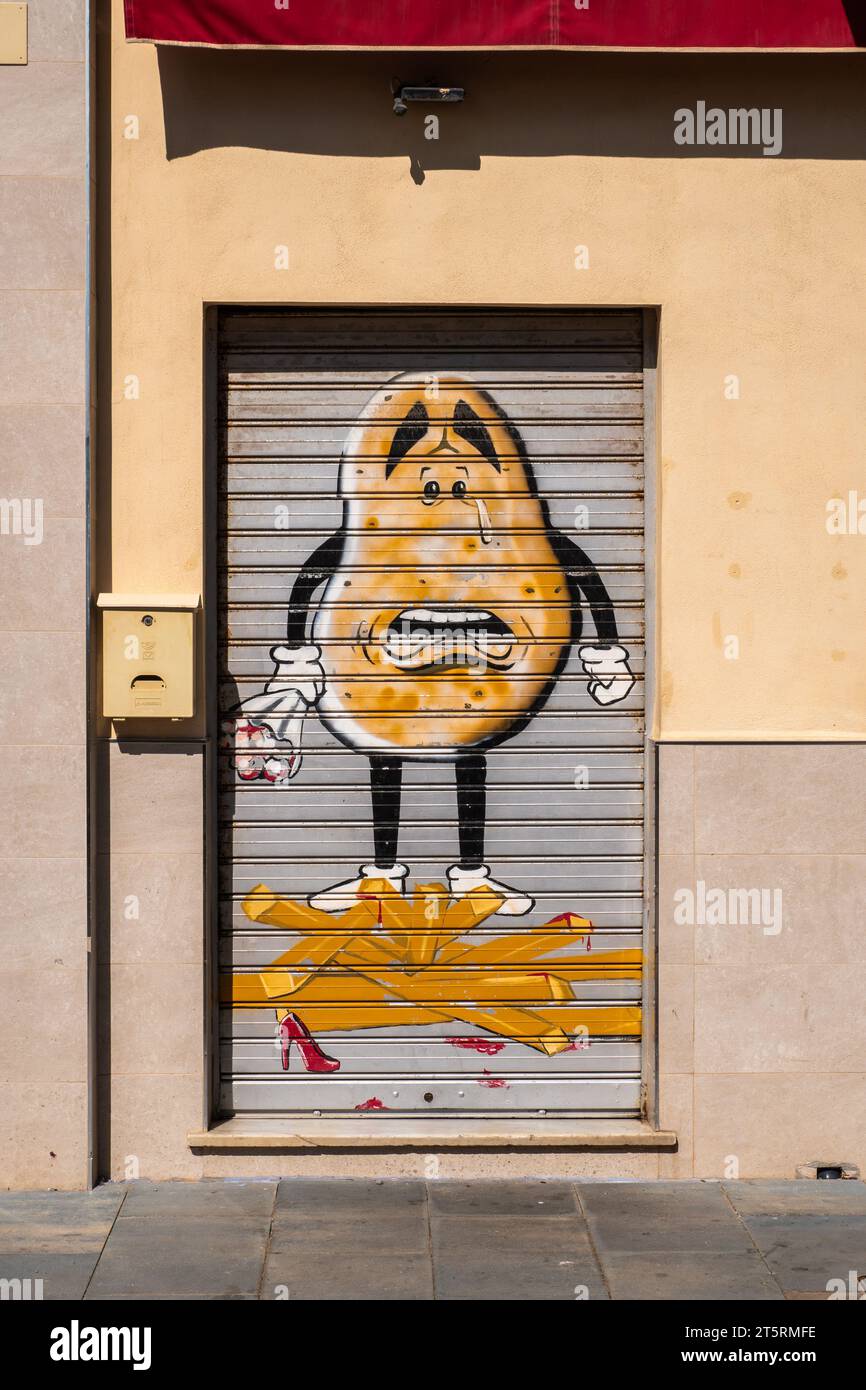 Graffiti von Mr. Potato Head auf einem Rollladen, der eine Tür bedeckt Stockfoto