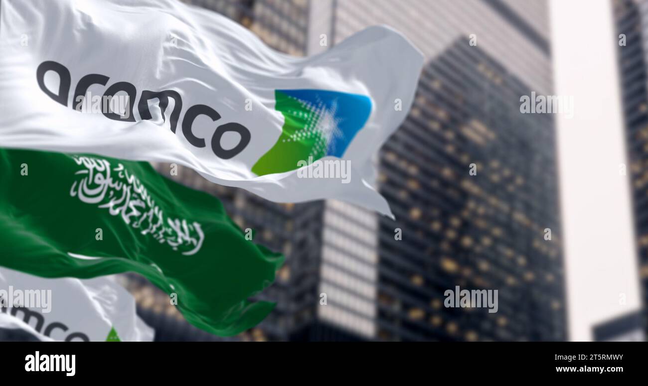 Dhahran, SA, 20. Oktober 2023: Flaggen von Aramco und Saudi-Arabien winken in einem Finanzviertel. Aramco ist das saudische Kohlenwasserstoffunternehmen. Illustrat Stockfoto