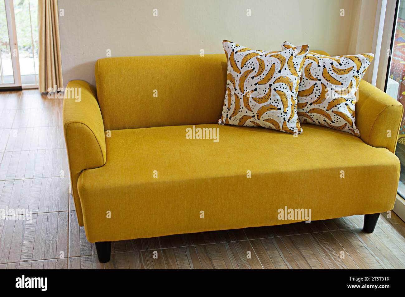 Wohnzimmerdekoration mit gelbem Sofa und Holzmaserboden Stockfoto