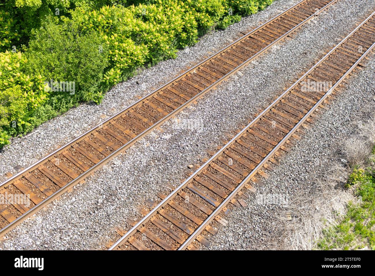 Blick aus der Vogelperspektive auf die Bahngleise - grüne Bäume - Kiesbett Stockfoto