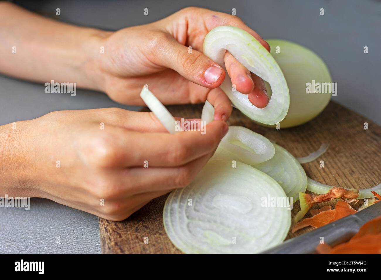 Schneiden Sie die rohen Zwiebeln in Ringe für Gemüsesalat Stockfoto