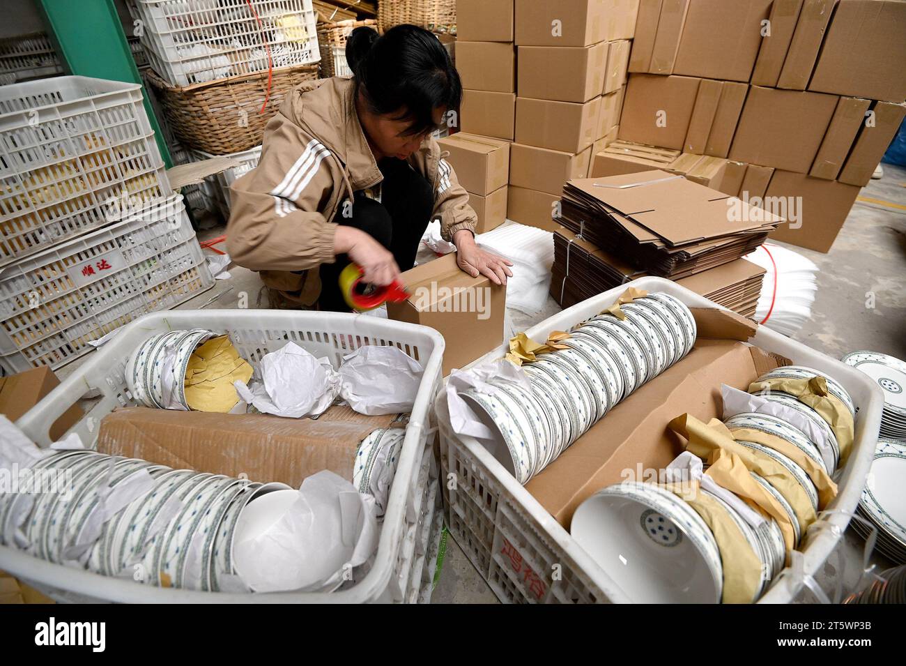 HANDAN, CHINA - 7. NOVEMBER 2023 - Ein Mitarbeiter eines Keramikunternehmens verpackt Keramikprodukte in Handan, Provinz Hebei, China, 7. November 2023. Stockfoto