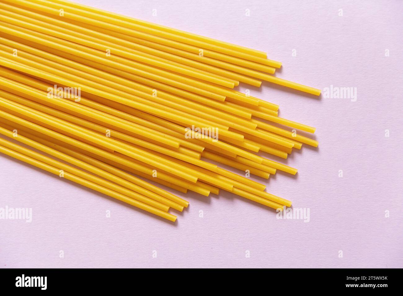 Sphagetti Bucatini Pasta auf rosa Hintergrund Stockfoto