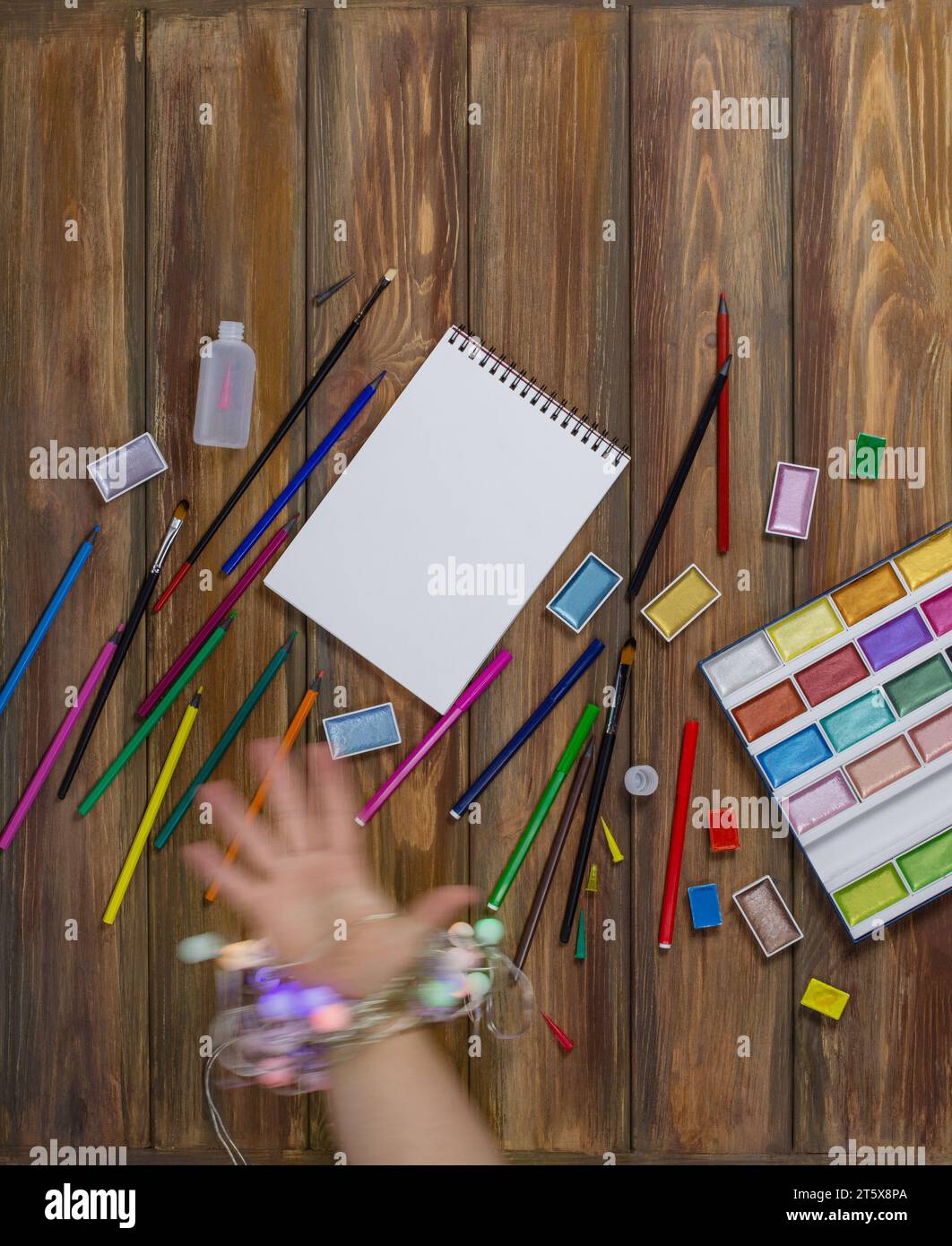 Leere weiße Seite des Notizblocks für Kopierraum. Overhead-Aufnahme eines weiblichen Künstlerarbeitsplatzes mit Skizzenblock und Malwerkzeugen. Stockfoto