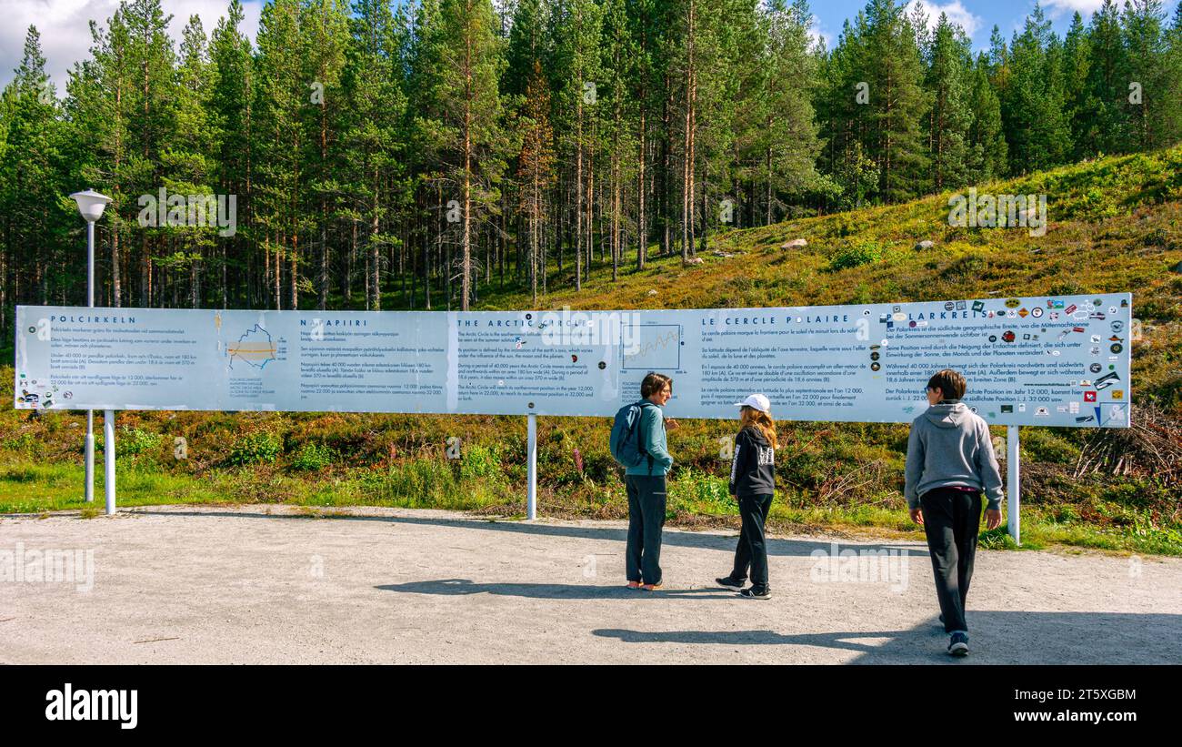 Eine Familie liest die Informationstafel über den Polzirkel in Schwedisch Lappland. JOKKMOKK, SCHWEDEN Stockfoto