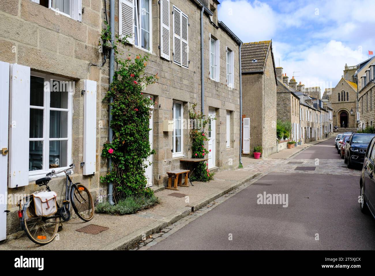 Frankreich, Barfleur, 27.08.2023: Typische Straße mit niedrigen Granithäusern in Barfleur auf der Halbinsel Cotentin an der franzoesischen Kanalkueste Stockfoto