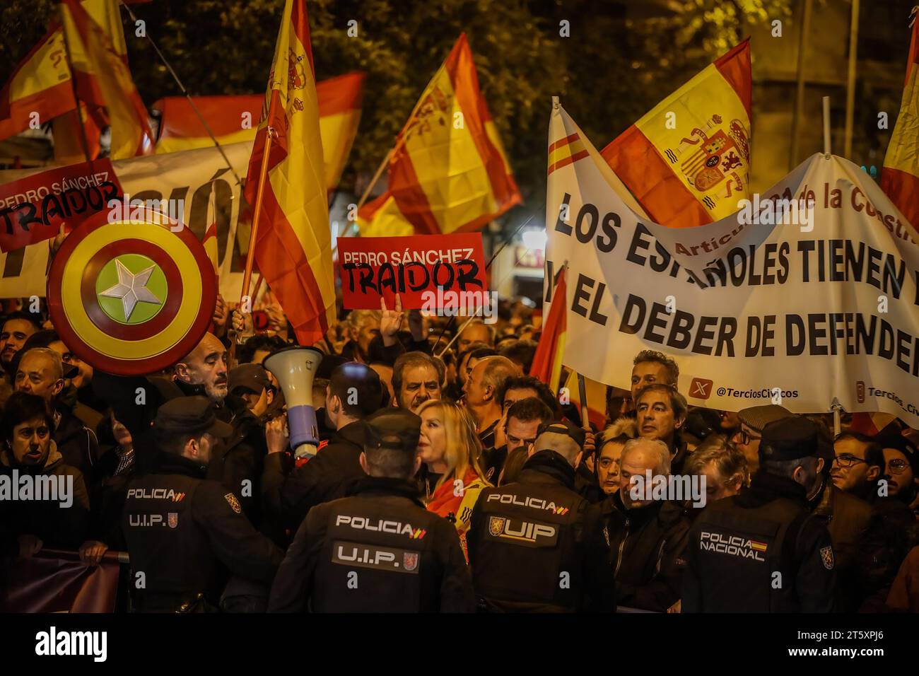 Madrid, Spanien. November 2023. Eine Gruppe von Demonstranten hält Fahnen und Banner, während die Polizei während der Kundgebung gegen die Amnestie katalanischer Politiker und gegen den amtierenden Präsidenten der spanischen Regierung, Pedro Sanchez, auf der Hut steht. Quelle: SOPA Images Limited/Alamy Live News Stockfoto