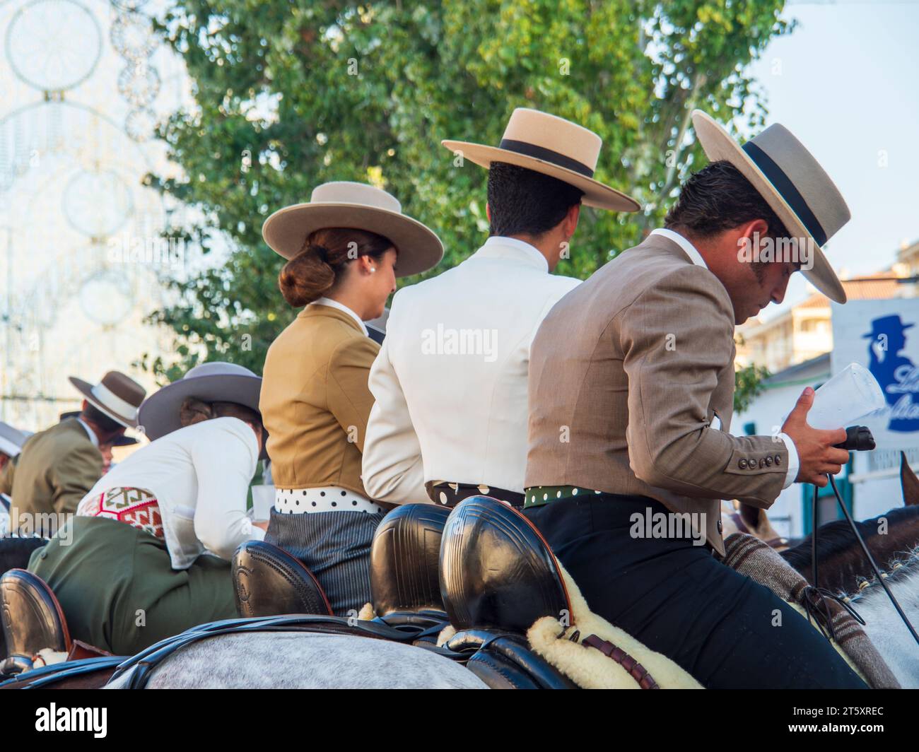 Gruppen von Reitern in typisch andalusischer Tracht, die während der Feria durch das Messegelände von Fuengirola reiten Stockfoto
