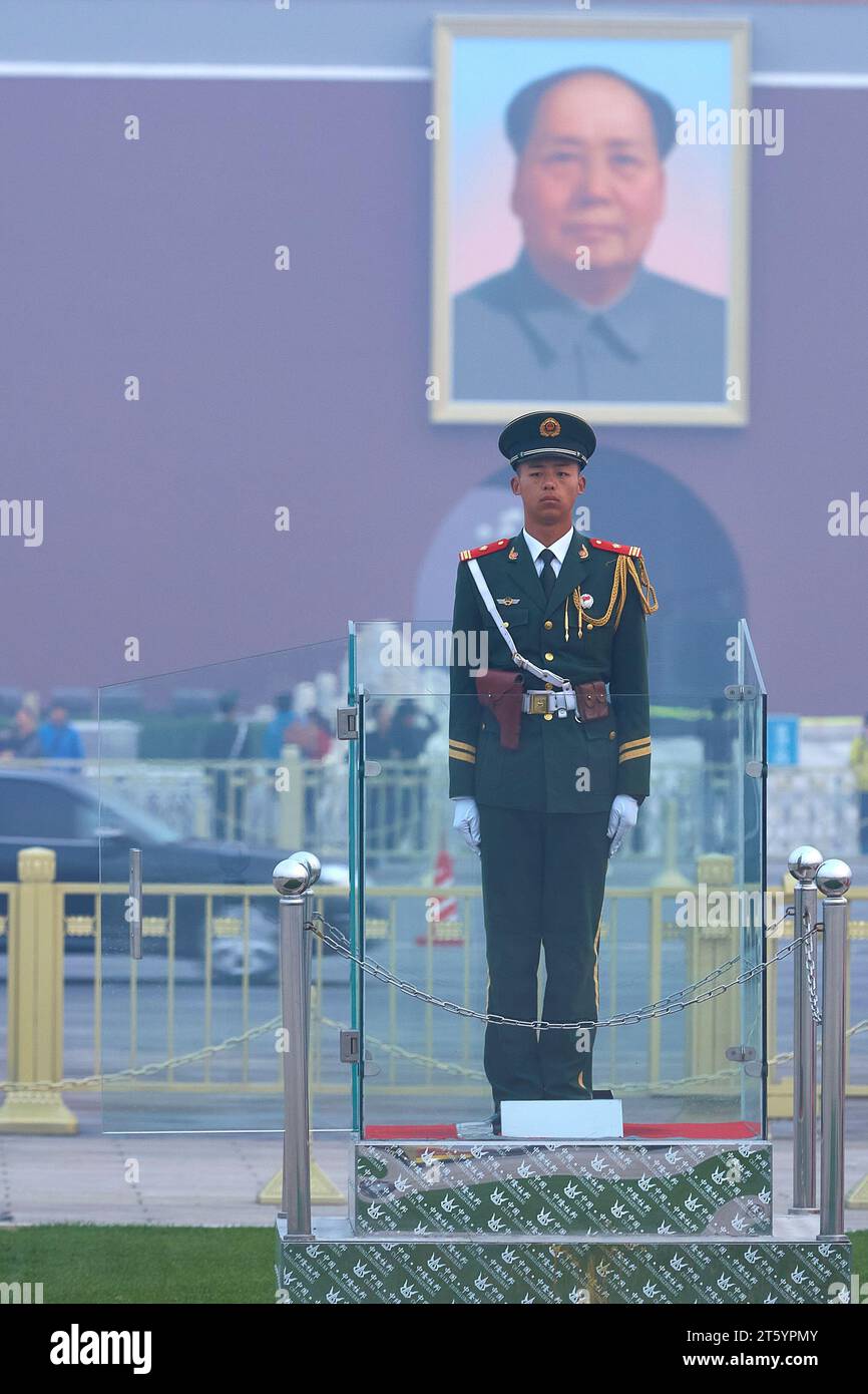 Ein Soldat der Jugendbefreiungsarmee steht auf dem Platz des Himmlischen Friedens. Ein Porträt von Mao Zedong dahinter. Peking, China. Stockfoto