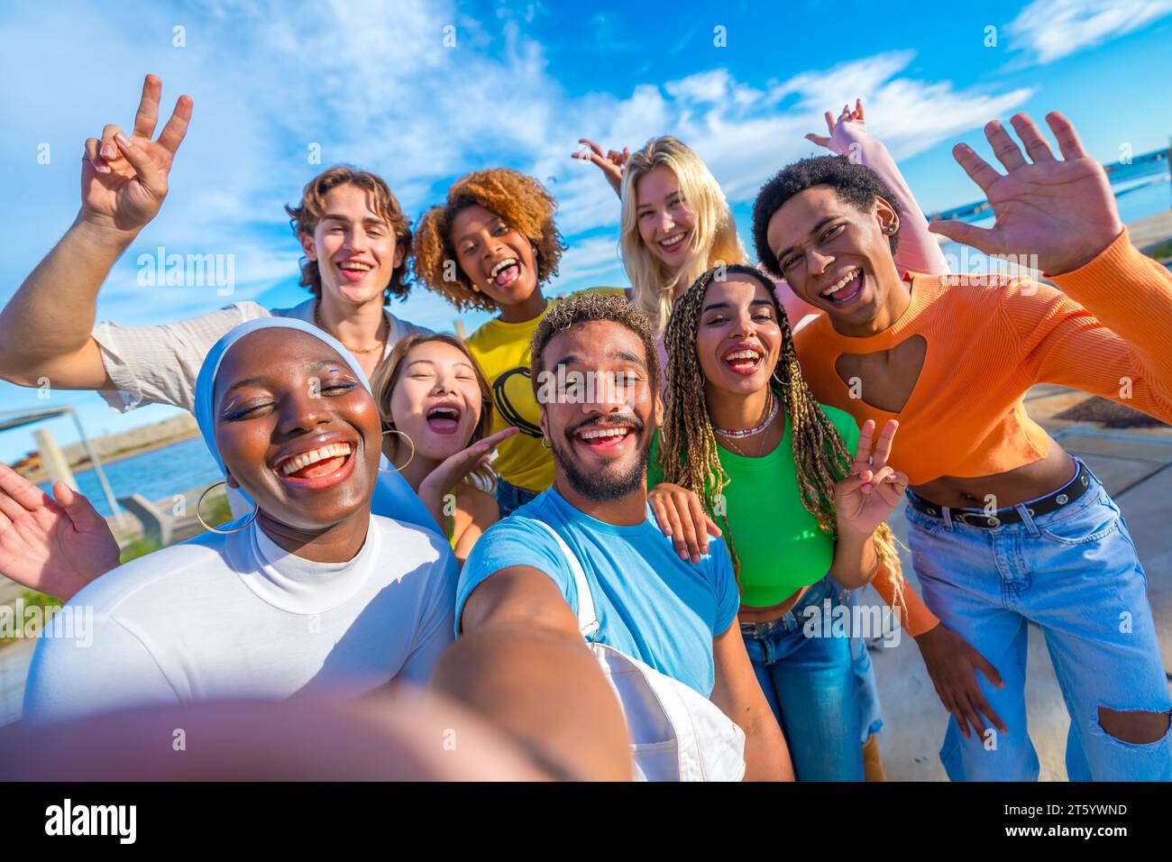 Glückliche multirassische Freunde, die ein Selfie machen und im Freien Gesten machen Stockfoto