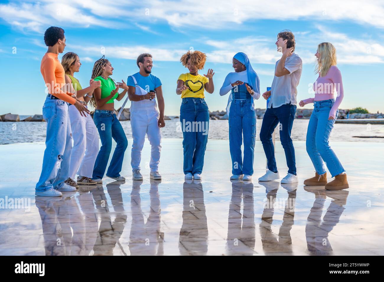 Junge Leute tanzen Freistil in einer Reihe draußen in einem urbanen Raum Stockfoto