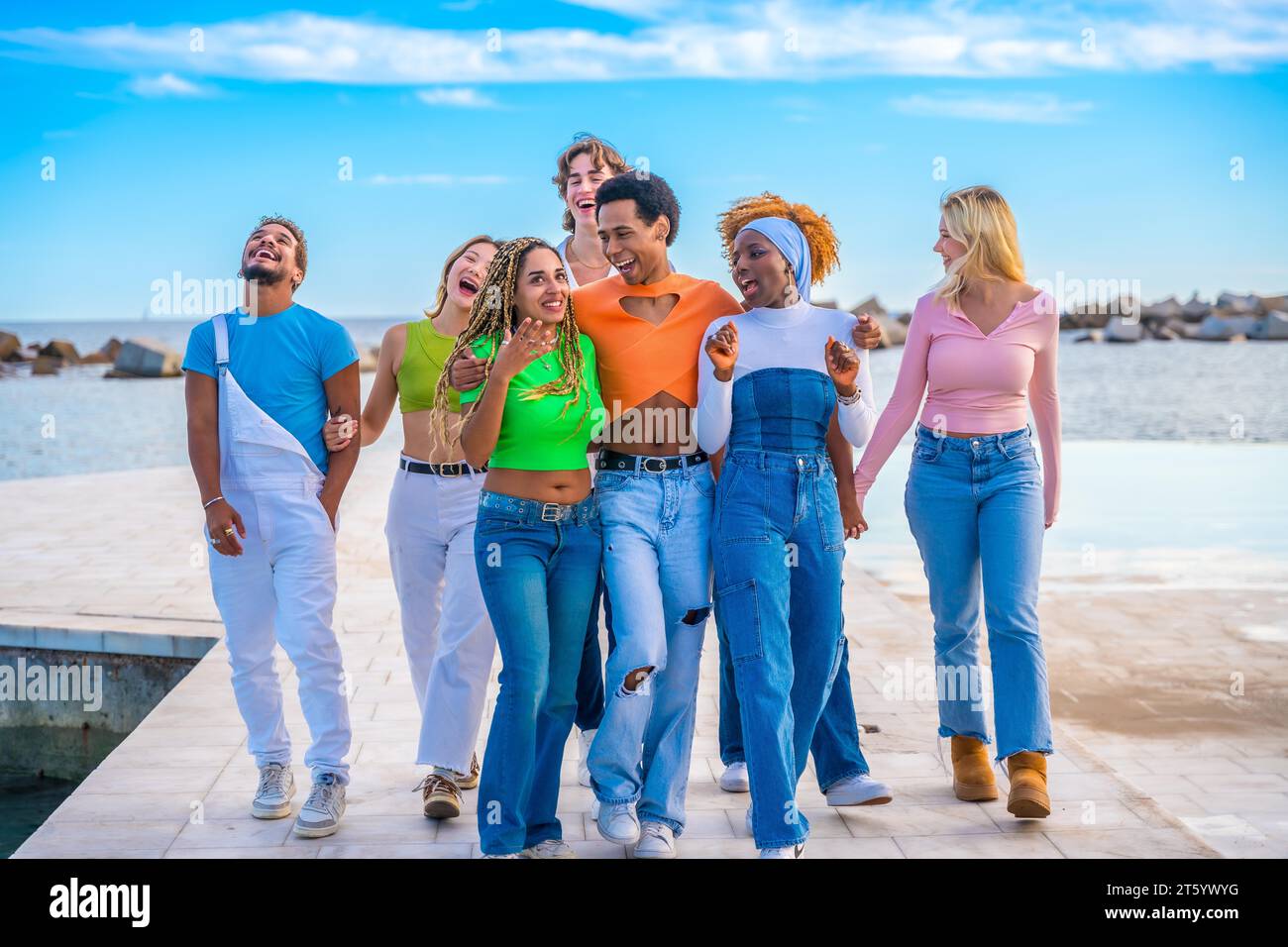 Glückliche Gruppe multikultureller Freunde, die am Meer spazieren und plaudern Stockfoto