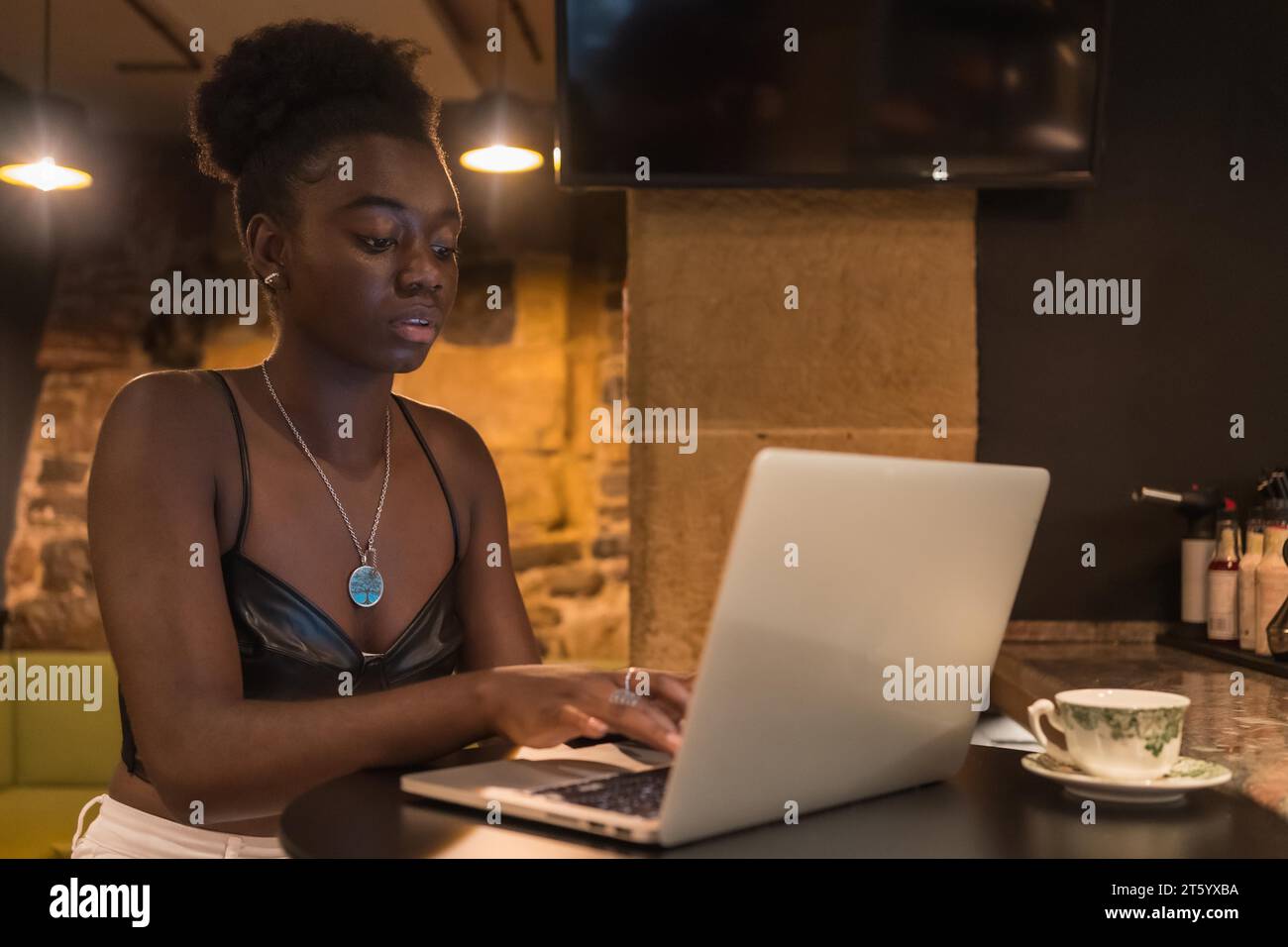 Konzentrierte junge afrikanerin mit Laptop in einer Cafeteria Stockfoto