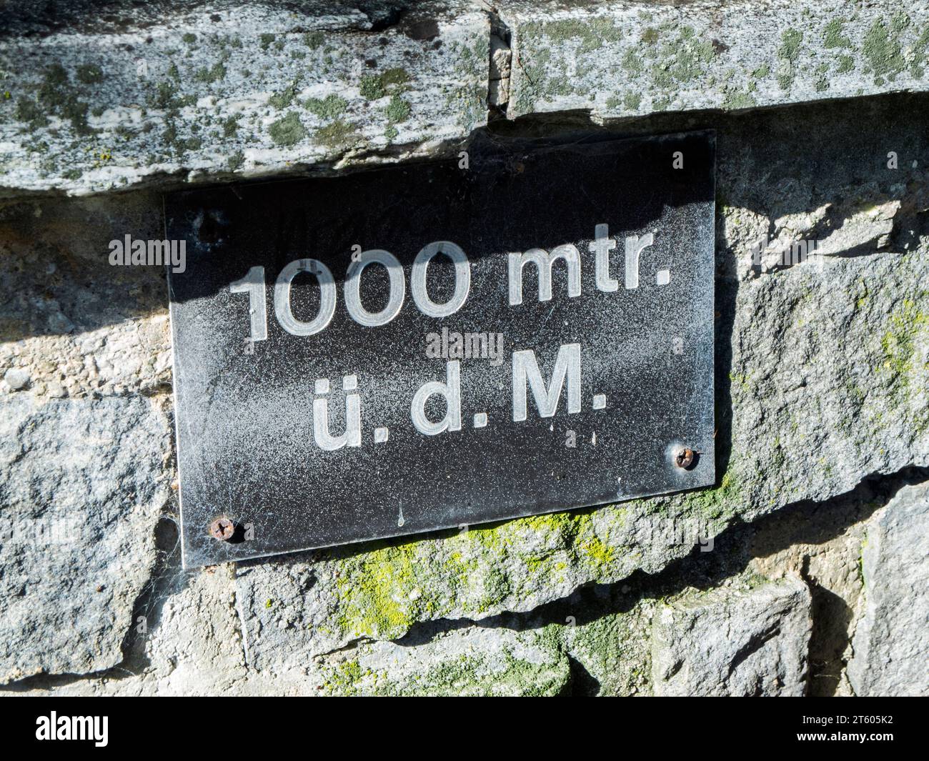 Nahaufnahme eines Schildes an einem Brunnen in Bayern, das besagt, dass es sich auf einer Höhe von 1000 Metern über dem Meeresspiegel befindet. Stockfoto