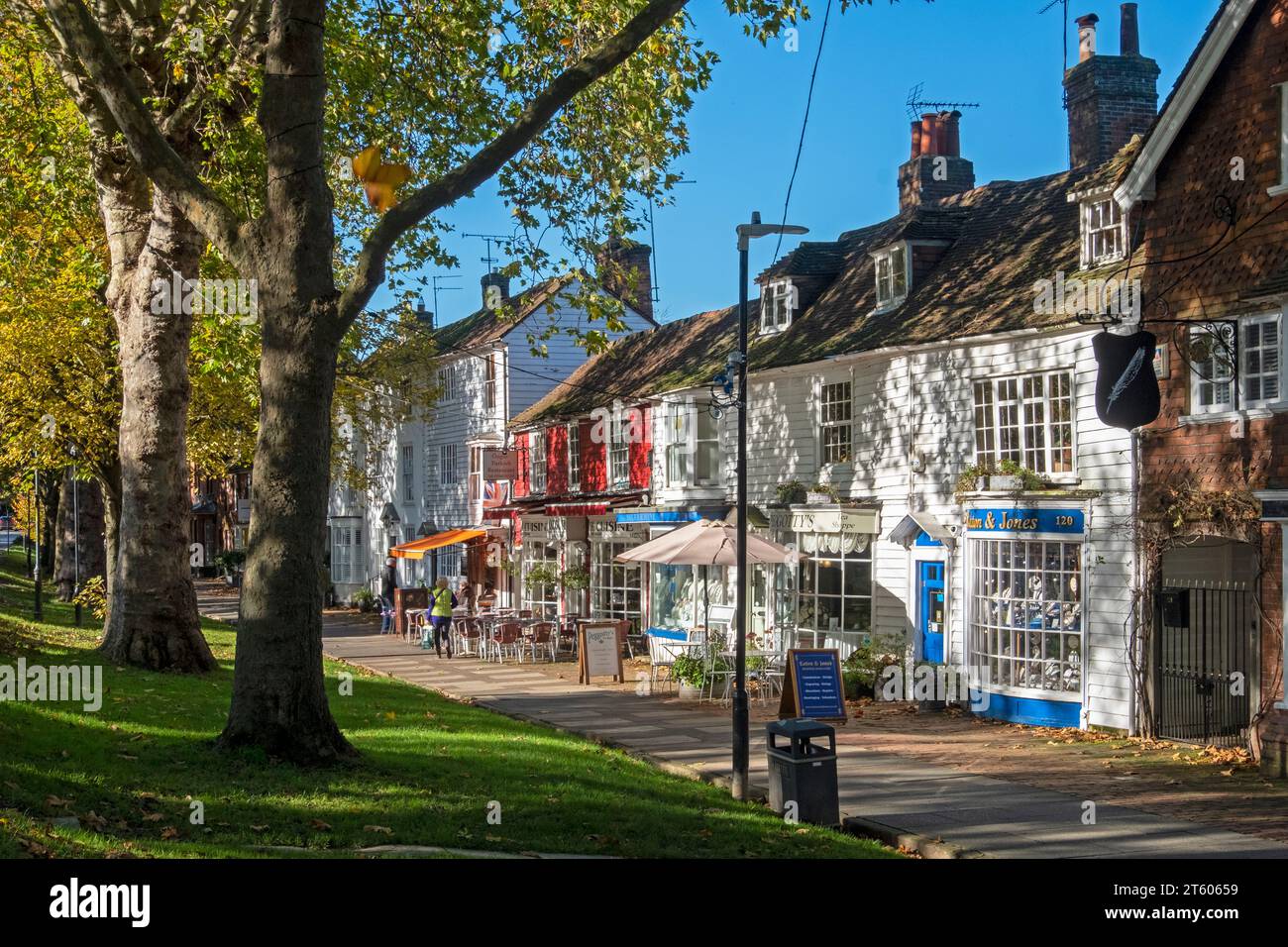 Tenterden High Street, breiter Bürgersteig mit Geschäften und Cafés, an einem sonnigen Herbsttag, Kent, Großbritannien Stockfoto