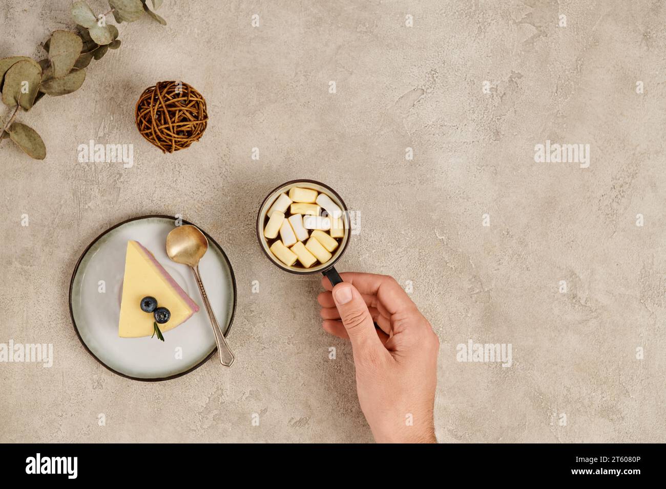 Abgeschnittene Ansicht einer Frau mit einer Tasse heißer Schokolade mit Marshmallows in der Nähe von süßem Weihnachtspudding Stockfoto