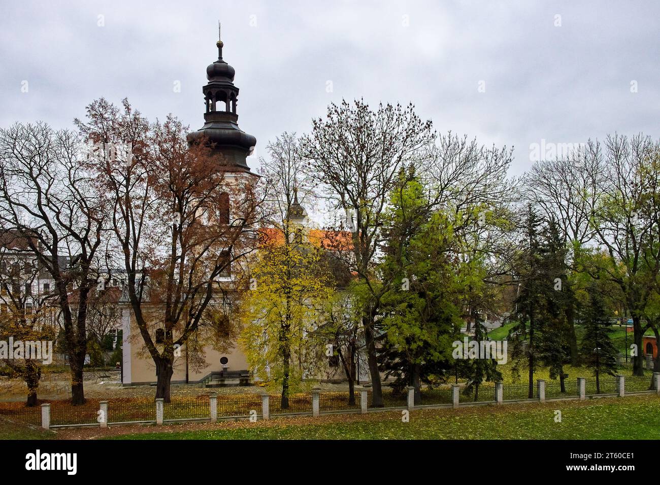 Römisch-katholische Kirche St. Nikolaus, Zamosc. Alte katholische Kirche umgeben von Herbstbäumen, Landschaft. Stockfoto
