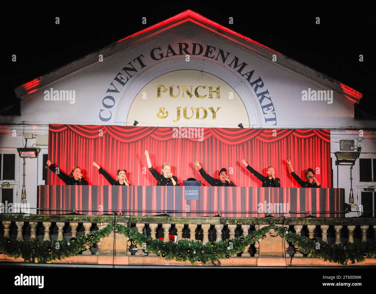 London, Großbritannien. November 2023. Die Besetzung der SECHS spielt. Nicole Scherzinger, Jamie Laing, Sophie Habboo, die Besetzung von SECHS The Musical und der London International Gospel Choir schalten die Weihnachtsbeleuchtung von Covent Garden auf der Piazza ein. Covent Garden Christmas Lights bieten ein neues Dekorationsschema – das erste seit fast einem Jahrzehnt – mit 40 gigantischen Glocken mit Bögen, 12 riesigen Kugeln und 8 drehenden Spiegelkugeln. Quelle: Imageplotter/Alamy Live News Stockfoto