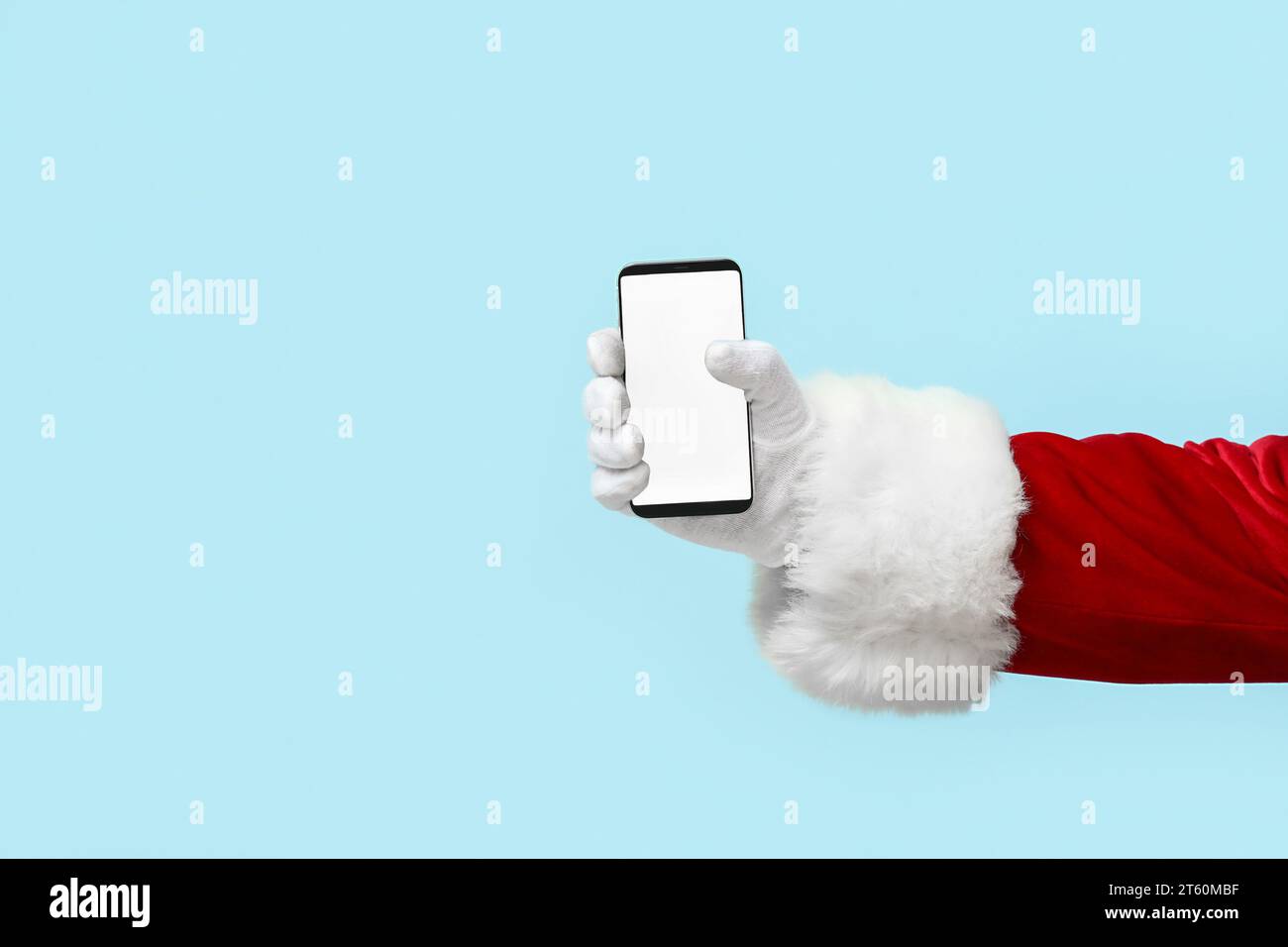 Weihnachtsmann mit Handy auf blauem Hintergrund Stockfoto