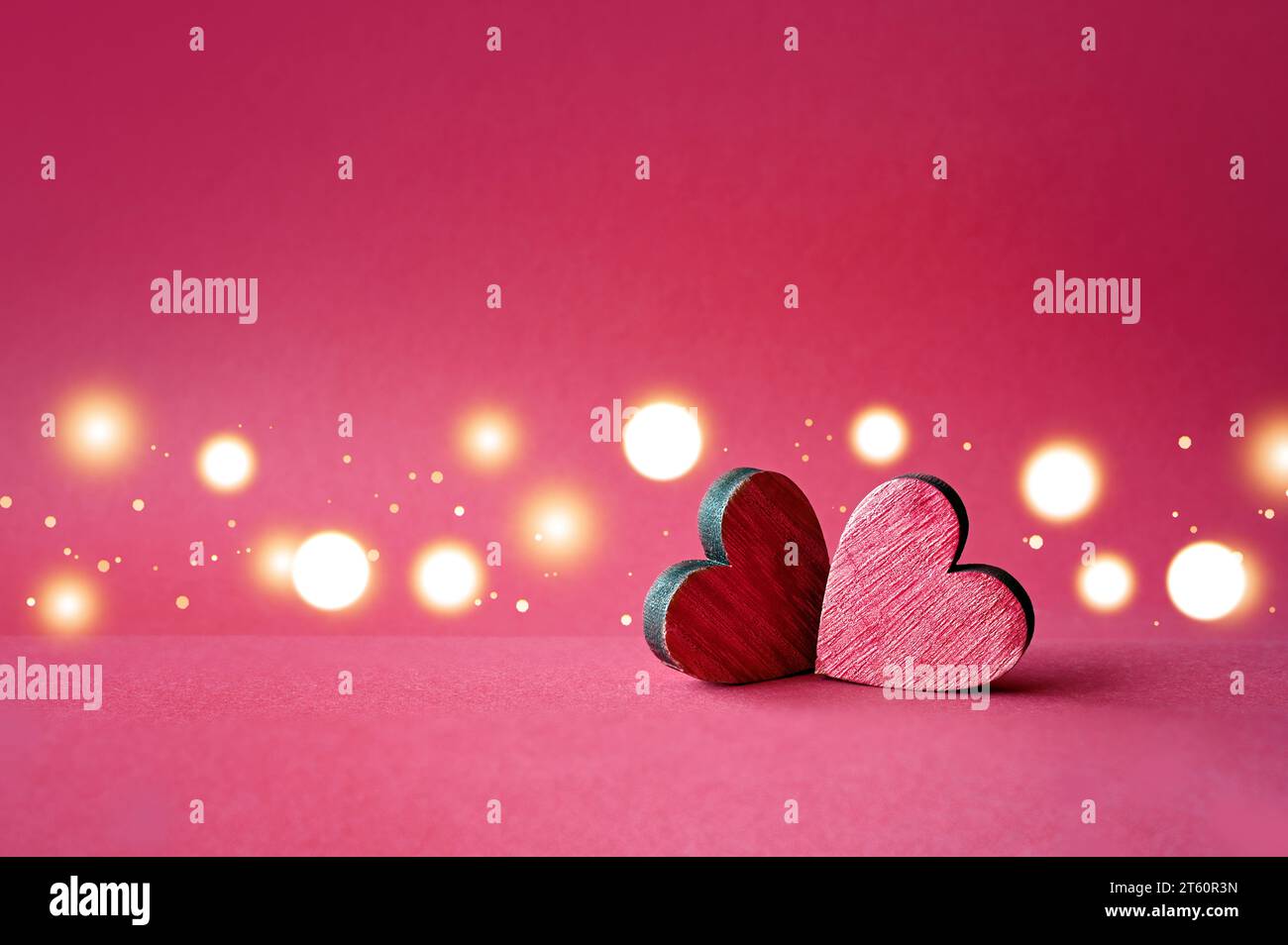 Zwei rote Valentinsholz-Herzen auf rotem Hintergrund. Stockfoto