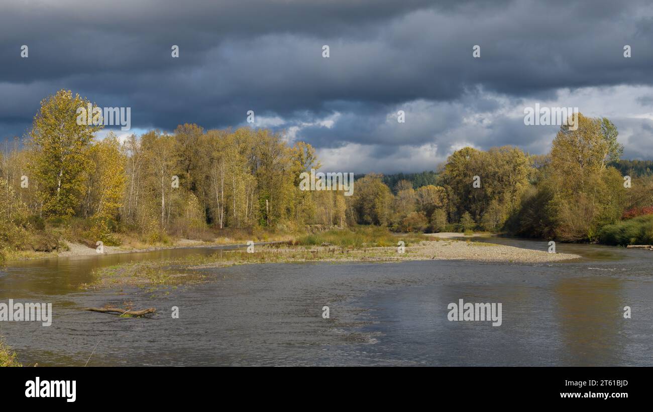 Sturmwolken über dem Snoqualmie River im späten Herbst mit niedrigem Wasserstand nach einem trockenen Sommer und frühen Herbst Stockfoto