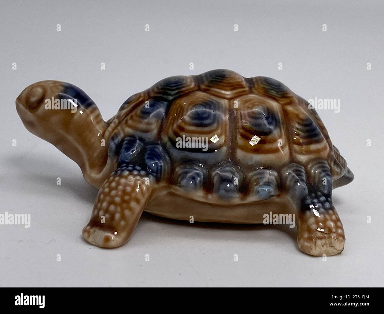 Eine Nahaufnahme einer grünen Keramikschildkrötenfigur auf weißem Hintergrund Stockfoto