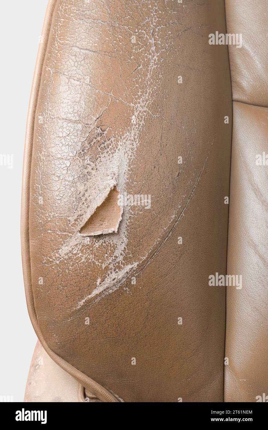 Nahaufnahme von gebrauchten, abgenutzten und zerrissenen Autositzen aus Leder, beigefarbener Sitz mit Verschleiß, einschließlich Abrieb, Falten und Kratzern, Reparatur Stockfoto