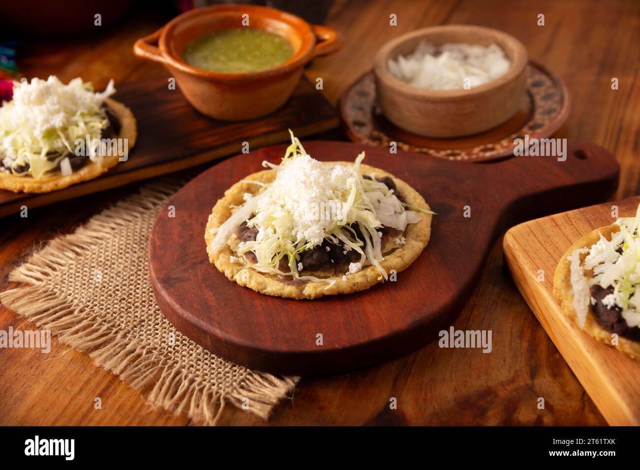 Sopes. Traditionelle hausgemachte mexikanische Gerichte, zubereitet mit flachgepresstem und auf der Grenze gepresstem Maisteig, bedeckt mit frischen Bohnen, grünen oder roten s Stockfoto