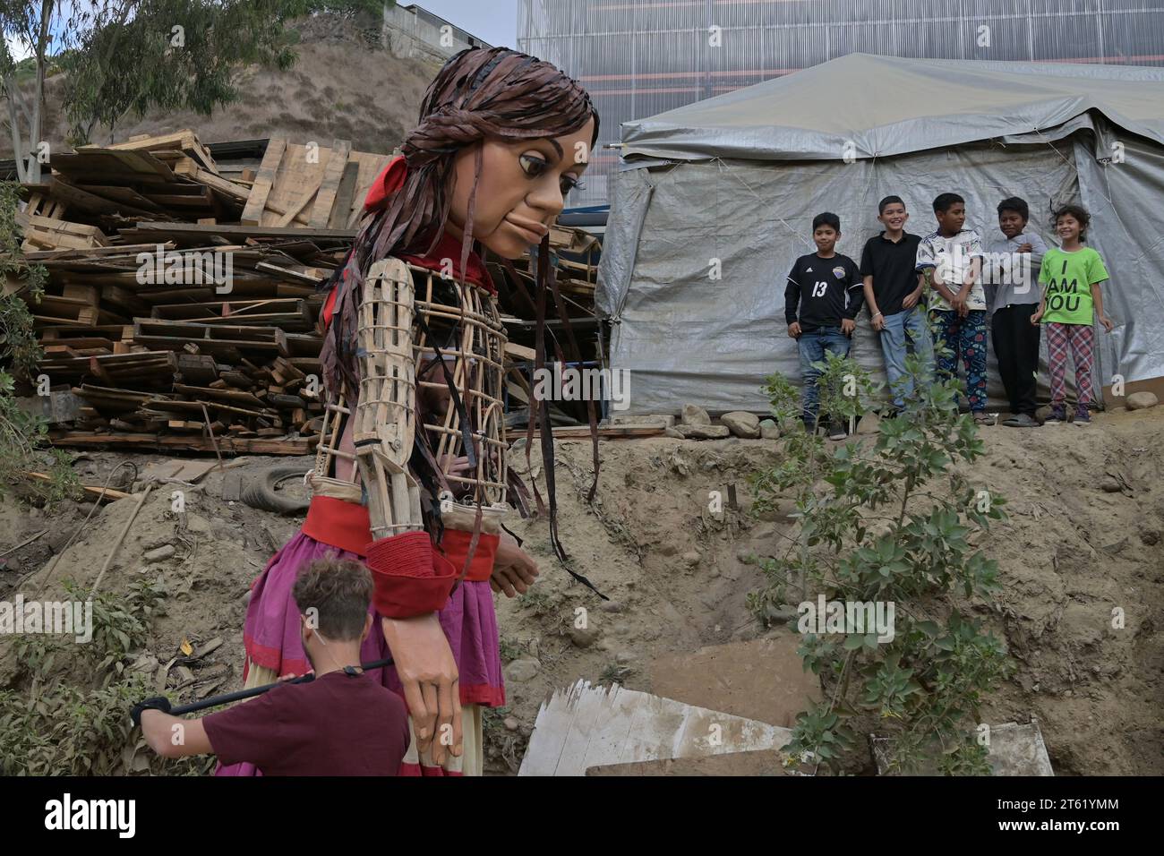 Tijuana, Baja California, Mexiko. November 2023. Little Amal, eine 12 Fuß große Marionette eines 10-jährigen syrischen Flüchtlings, schloss ihren Besuch in Tijuana, Mexiko, am Dienstag, den 7. November 2024, in der Embajadores de Jesus-UCSD Alacran Canyon, einem der größten Unterkünfte für Migranten, ab. Die Marionette setzt ihre lange Wanderung durch Mexiko fort, nachdem sie zwei Monate zuvor eine 6.000 Meilen lange Reise in die Vereinigten Staaten absolviert hat. (Kreditbild: © Carlos A. Moreno/ZUMA Press Wire) NUR REDAKTIONELLE VERWENDUNG! Nicht für kommerzielle ZWECKE! Stockfoto