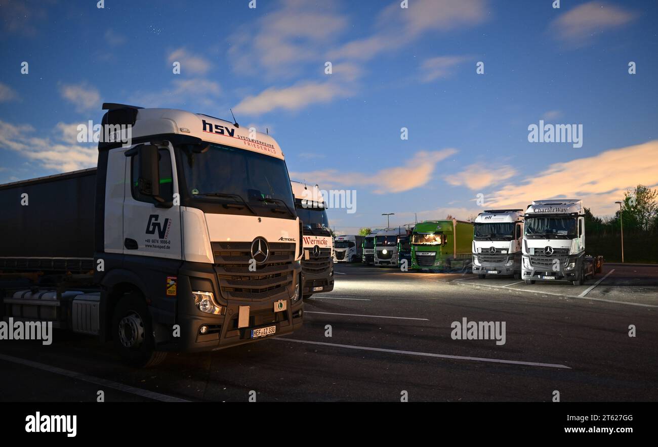 Stuttgart, Deutschland. November 2023. LKWs parkten nachts an einer Servicestelle an der Autobahn 8 bei Denkendorf. Logistikverbände und Lkw-Hersteller sprechen auf einer Pressekonferenz über die Rahmenbedingungen in der Branche. Quelle: Bernd Weißbrod/dpa/Alamy Live News Stockfoto