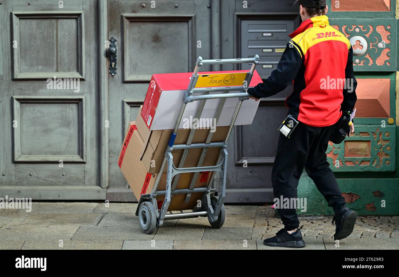 Erfurt, Deutschland. November 2023. Ein DHL-Mitarbeiter liefert Sendungen in der Innenstadt von Erfurt. Quelle: Martin Schutt/dpa/Alamy Live News Stockfoto