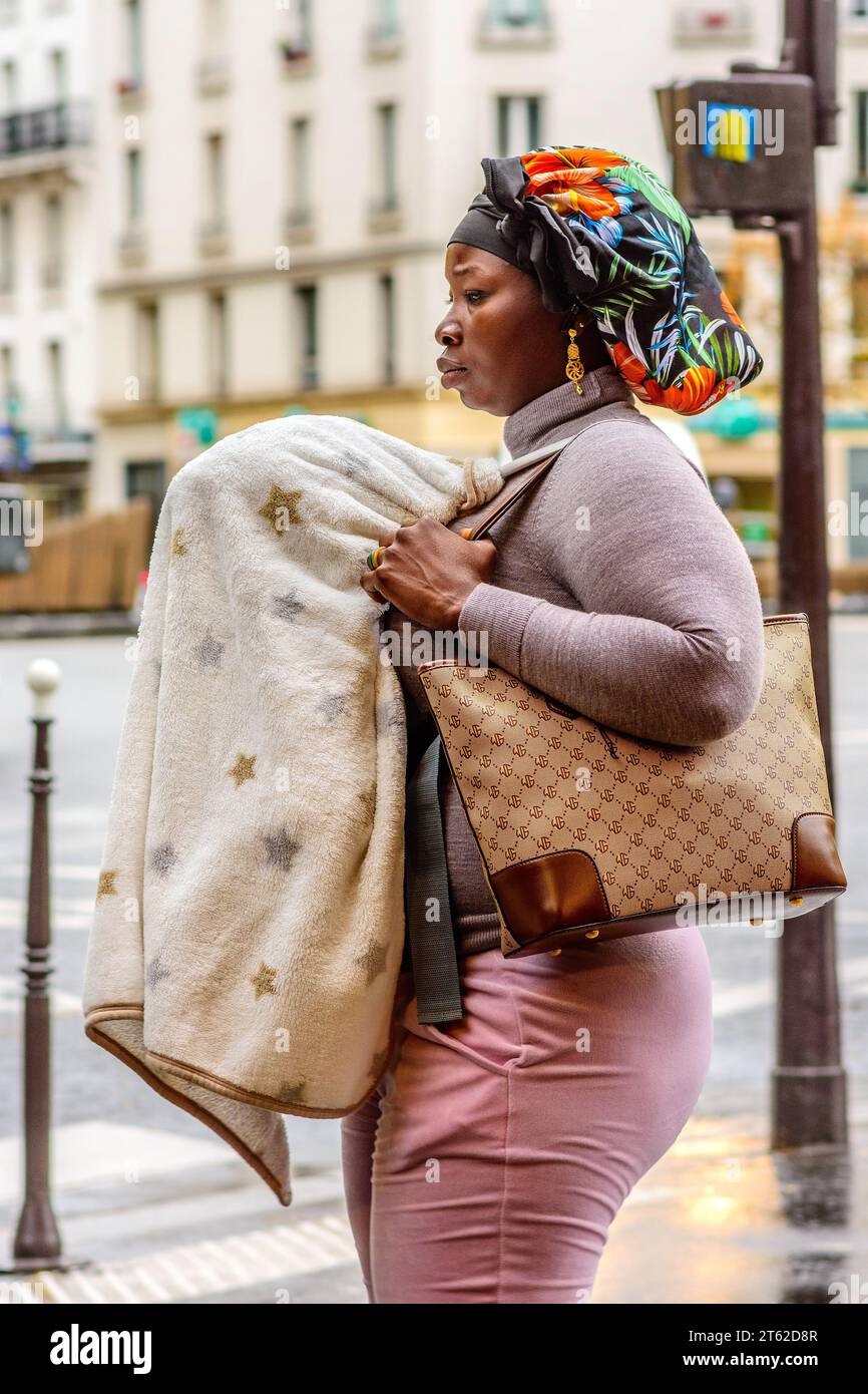 Schwarze französisch-afrikanische Frau mit Baby bedeckt mit Schal - Paris 20, Frankreich. Stockfoto