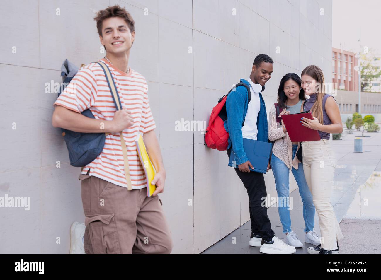 Glücklicher Student auf dem Campus, der draußen in die Kamera lächelt. Stockfoto