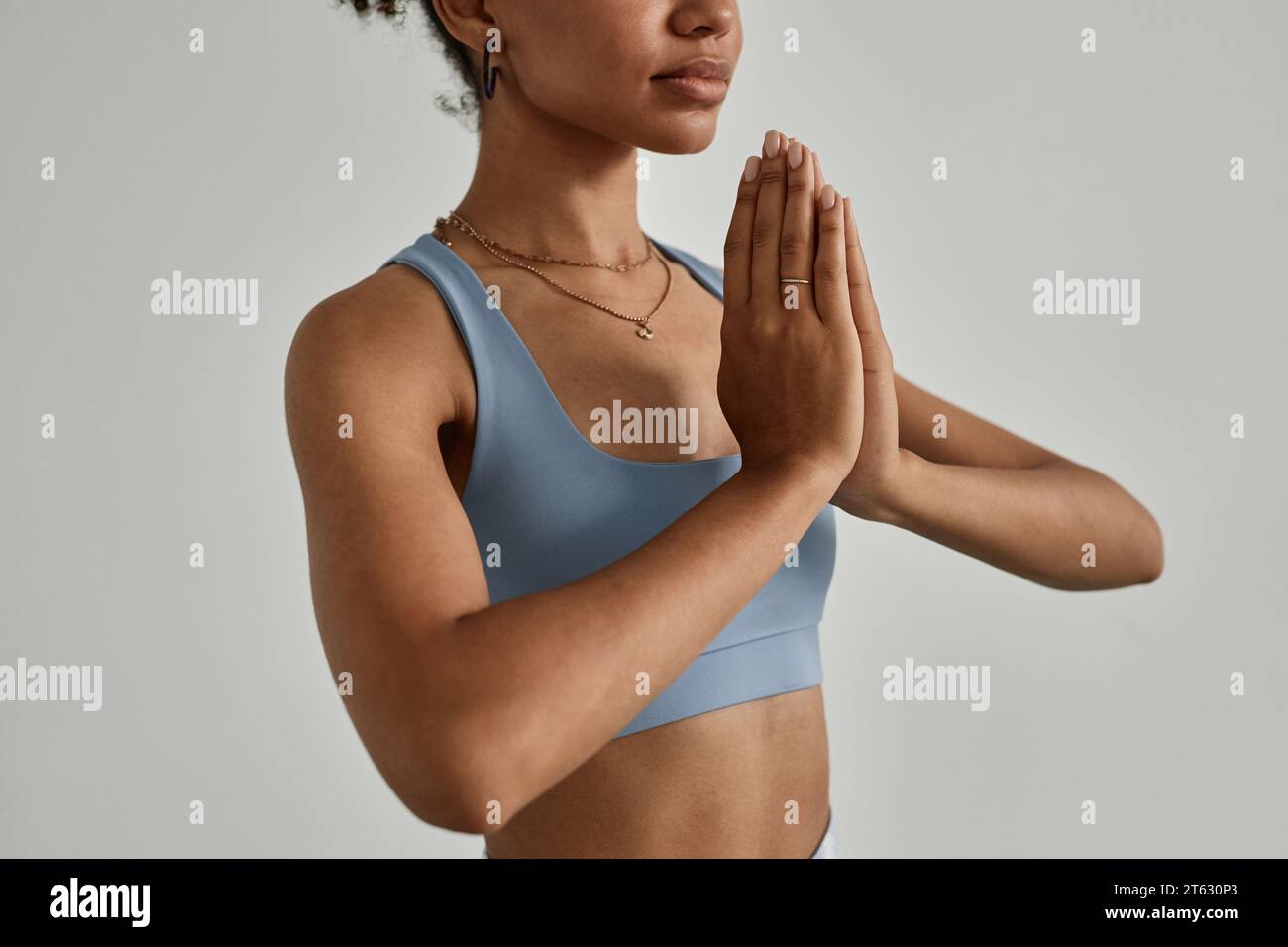 Minimale Nahaufnahme einer schwarzen jungen Frau, die mit geschlossenen Augen meditiert, im Yoga-Studio, Kopierraum Stockfoto