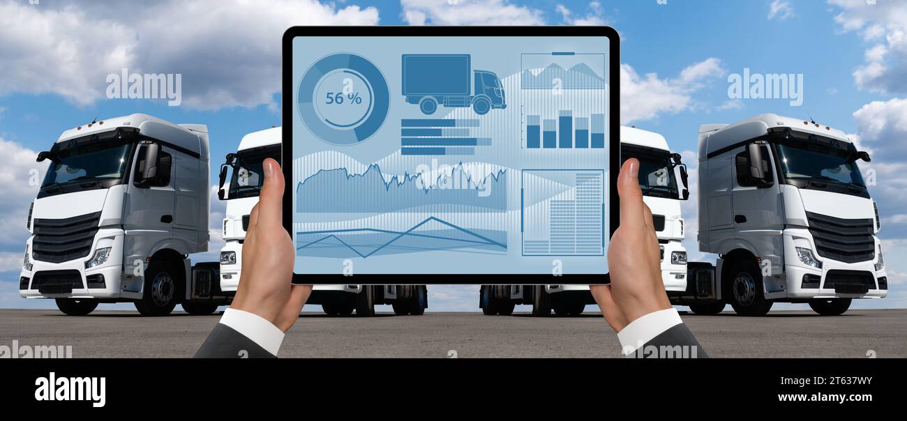 Manager mit einem digitalen Tablet im Hintergrund von Lkws. Flottenmanagement... Stockfoto