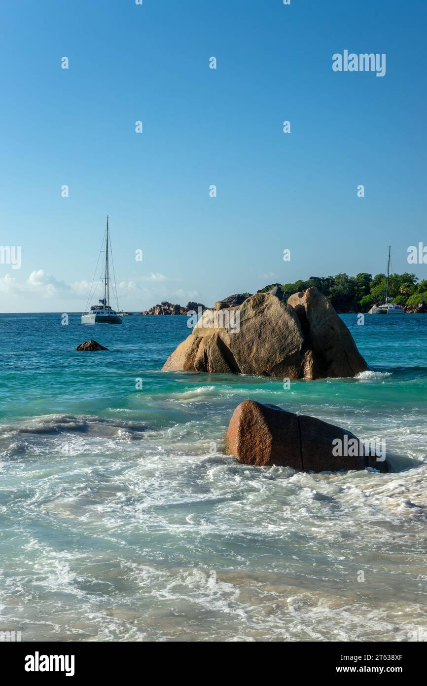 Granitfelsen und Segelboote in Anse Lazio, malerischer Strand auf Praslin Island, Seychellen Stockfoto