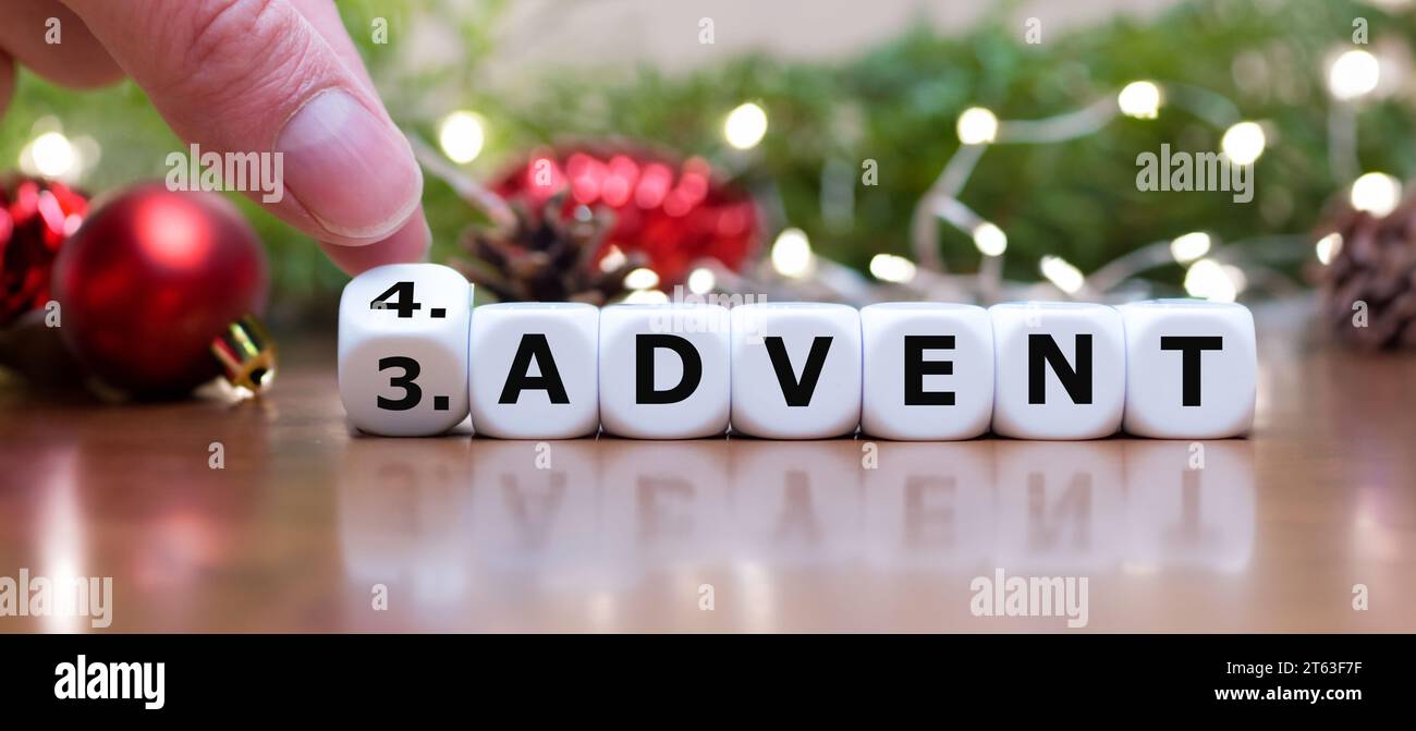 Die Hand dreht Würfel und ändert den Ausdruck „Dritter Advent“ in „vierter Advent“. Stockfoto
