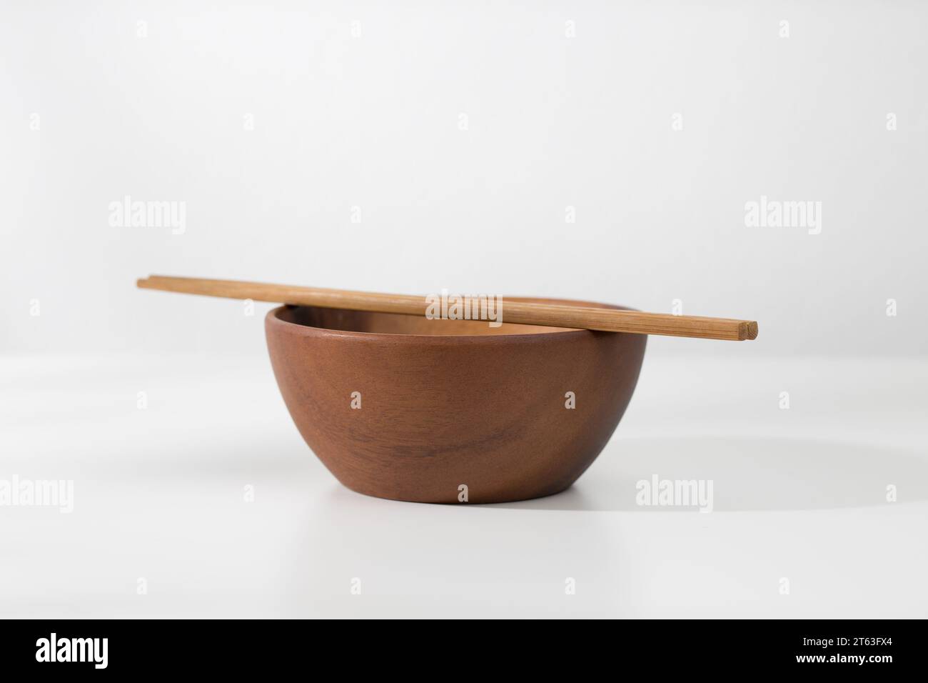 Eine leere Holzschale und Essstäbchen auf dem Tisch. Stockfoto