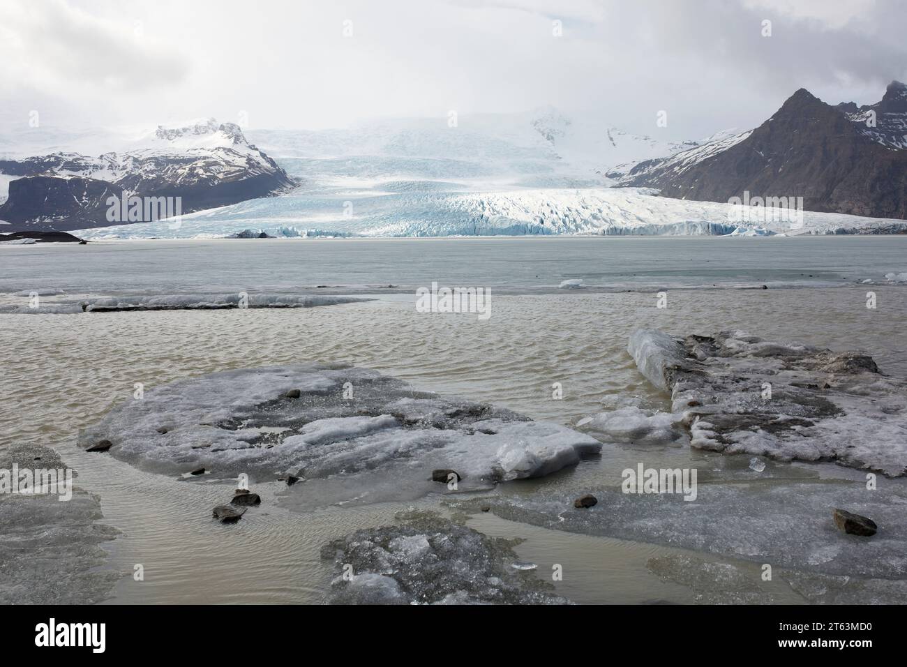 Malerischer Blick auf Gletscher und gefrorenen See mit schneebedeckten Bergen gegen Himmel im Winter auf Island Stockfoto