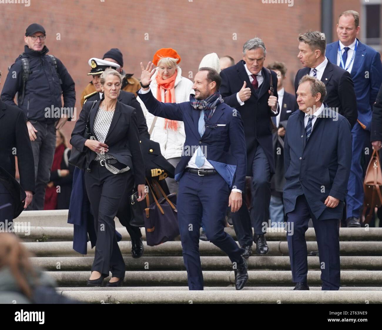 Hamburg, Deutschland. November 2023. Der norwegische Kronprinz Haakon (M) winkt den Schülern neben Jens Kerstan (vorne rechts, Allianz 90/die Grünen), Senator für Umwelt, Klima, Energie und Landwirtschaft in Hamburg, in der Elbphilharmonie zu. Der norwegische Kronprinz ist zu einem viertägigen Besuch nach Deutschland gekommen. Quelle: Marcus Brandt/dpa/Alamy Live News Stockfoto