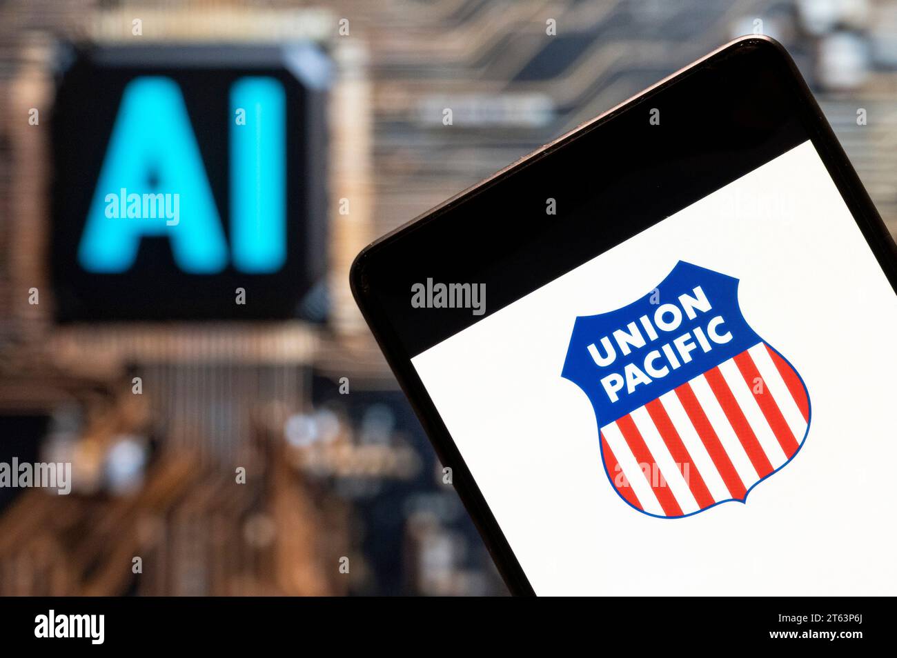 In dieser Fotoabbildung ist das Logo der amerikanischen Eisenbahnholdinggesellschaft Union Pacific (NYSE: UNP) auf einem Smartphone mit einem Chip und Symbol für künstliche Intelligenz (KI) im Hintergrund zu sehen. Stockfoto