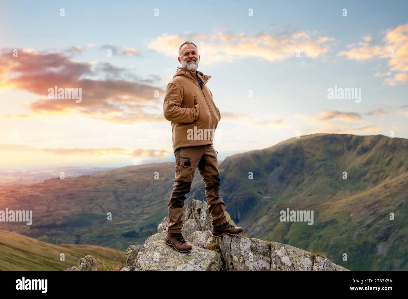 Happy Bearded man erreicht das Ziel und auf der Spitze des Berges bei Sonnenuntergang am Herbsttag Travel Lifestyle Konzept der Nationalpark Lake District Stockfoto