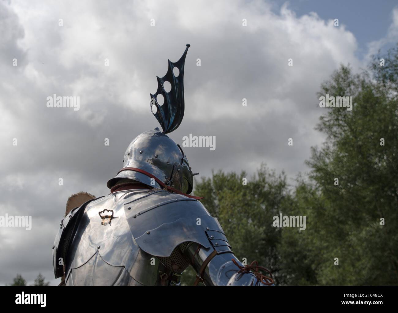 Kenilworth England 29. Juli 2023 Ein Ritter in glänzender Rüstung reitet auf seinen Pferden gegen eine bewölkte Himmelsilhouette seines Steuerstandes Stockfoto