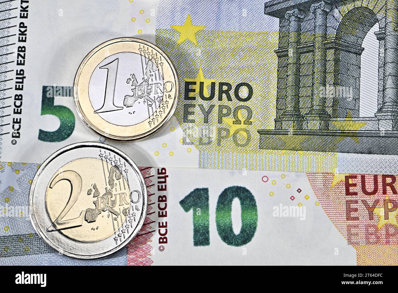 1- und 2-Euro-Münzen auf 5- und 10-Euro-Banknoten Stockfoto