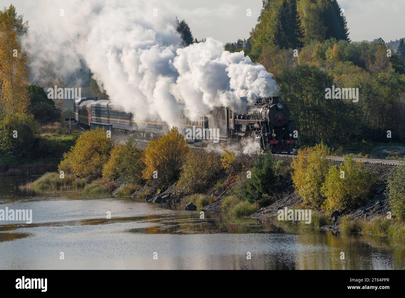 HELYULYA, RUSSLAND - 06. OKTOBER 2023: Retro-Zug 'Ruskeala Express' in der Herbstlandschaft. Karelien Stockfoto